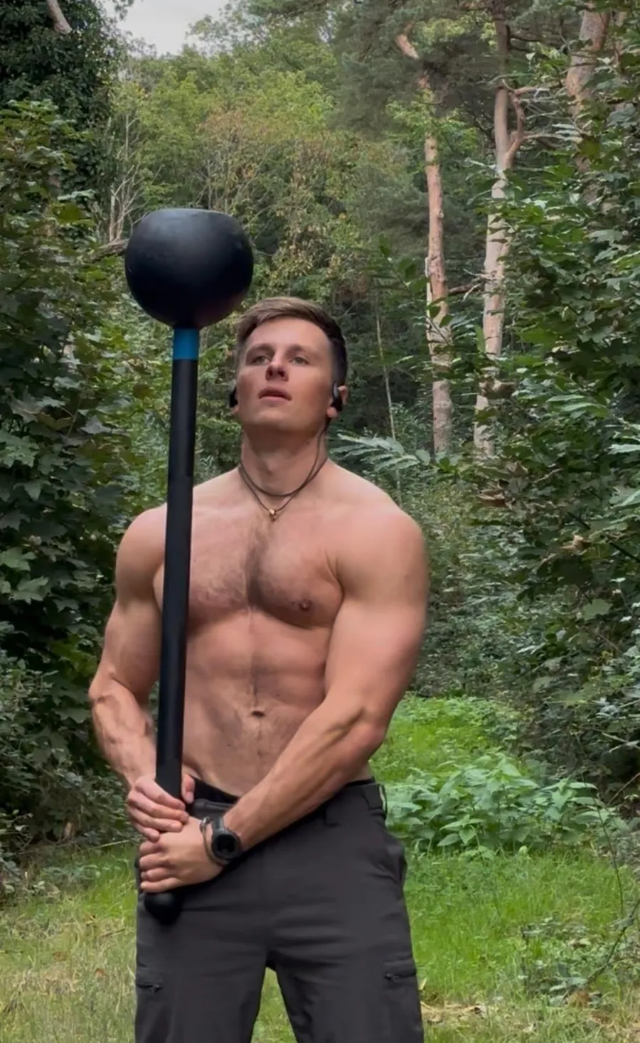 Mike holding a steel mace upright in the woods