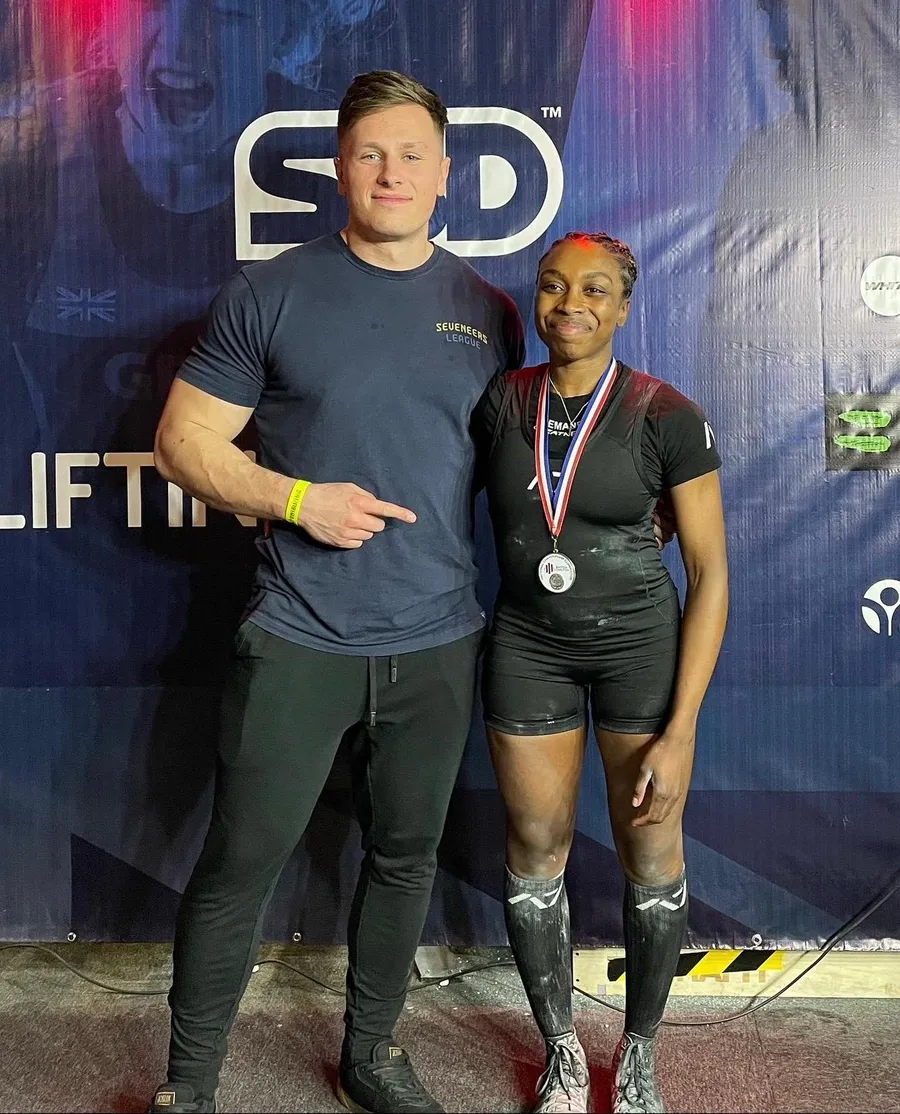 Mike with a client holding a medal at a powerlifting meet
